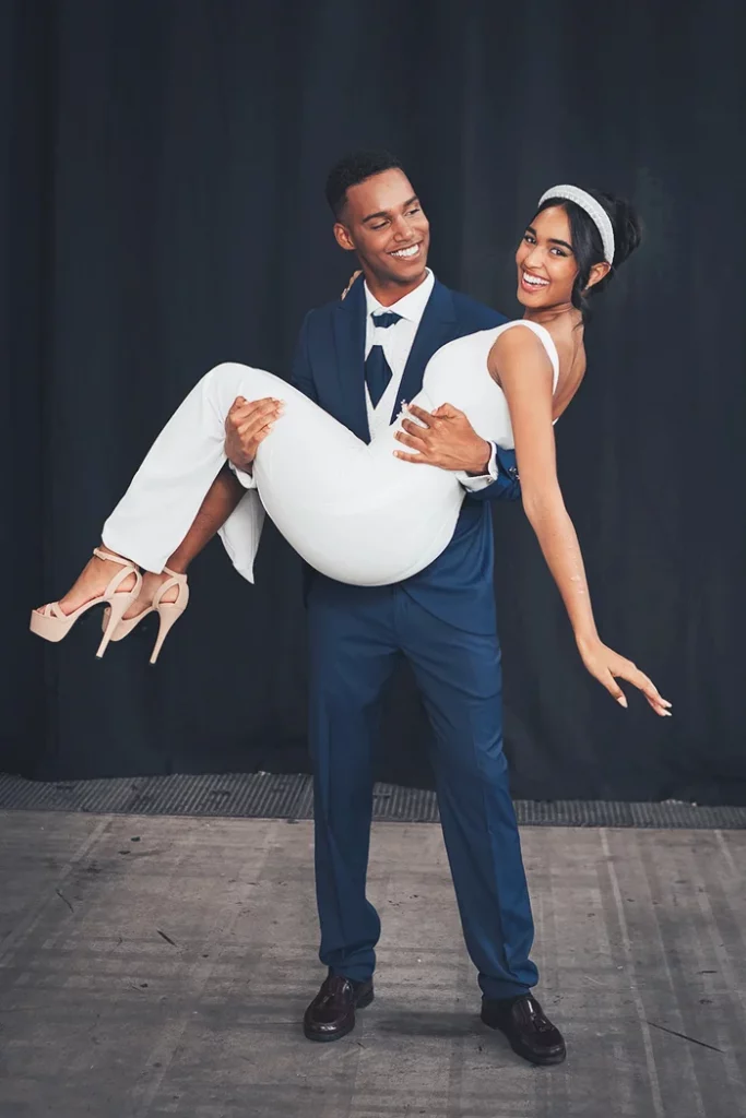 Modelo de La Botiga Roba d’Home con traje de novio posando junto a modelo con vestido de novia